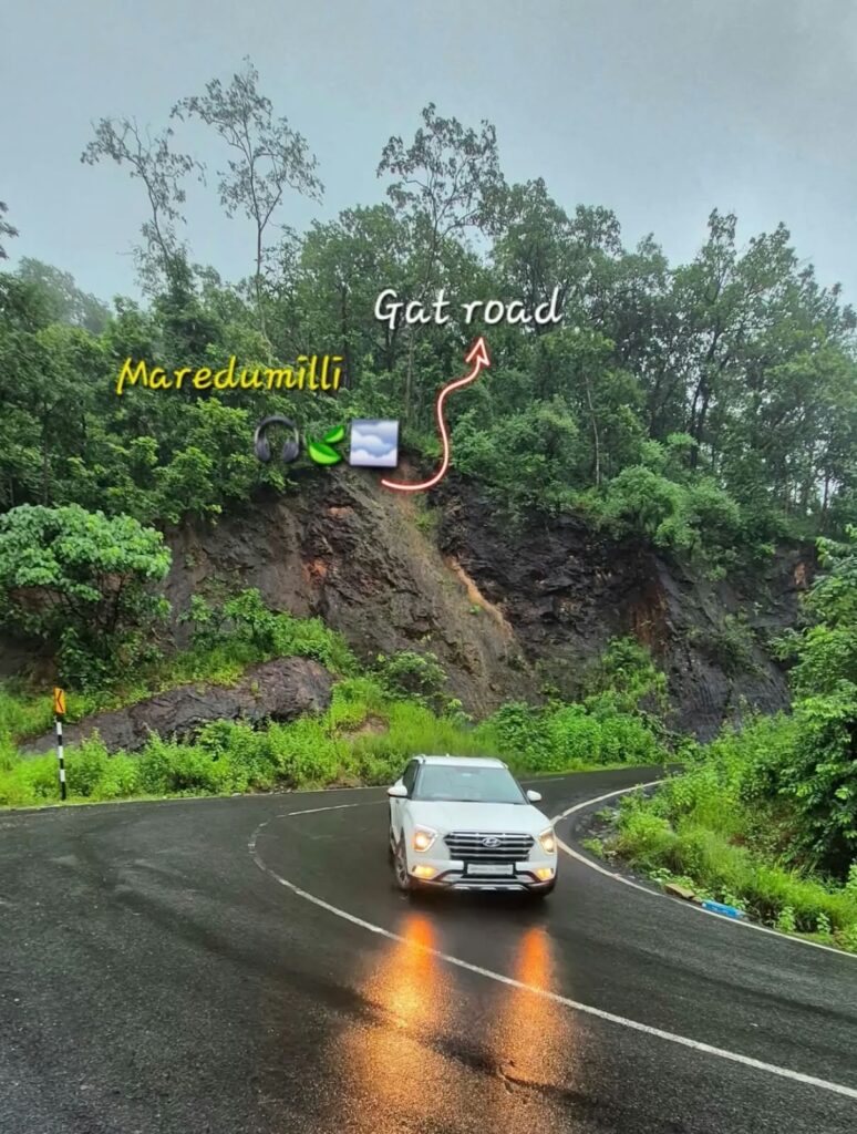 White SUV driving on the wet Maredumilli ghat road through green forest